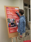 Jaś Kapela składa pamiątkowy autograf na plakacie promującym spotkanie