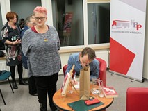 Jaś Kapela składa autografy. Obok niego, po lewej trzy czytelniczki w kolejce po autograf