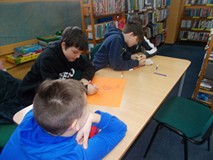 Dzieci pracują w grupach i tworzą reklamy