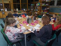 Dzieci siedzą przy stole podczas rozmowy o przeczytanej książce