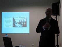 Fragment prezentacji na temat Romów. Na slajdzie widnieje brama wjazdowa obozu Auschwitz-Birkenau, o