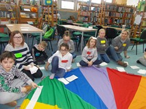 Dzieci siedza na chuście animacyjnej podczas wspólnej zabawy