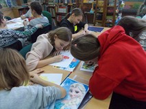 Dzieci siedza przy stolikach podczas wykonywania pracy plastycznej