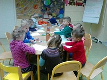 Dzieci przy stole rysują ilustracje do wysłuchanej książki