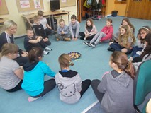 Dzieci siedą w kole na dywanie podczas wspólnej zabawy