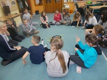 Dzieci siedą w kole na dywanie podczas wspólnej zabawy