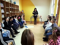 Bibliotekarka prezentuje dzieciom książki o przyjaźni