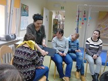 Bibliotekarka czyta podopiecznym książkę