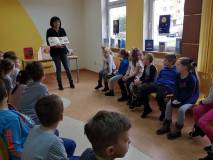 Bibliotekarka prezentuje dzieciom książki z naszych zbiorów.