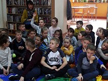 Dzieci odpowiadają na zadawane przez bibliotekarkę pytania.