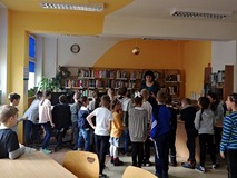Dzieci wraz z bibliotekarką zwiedzają bibliotekę