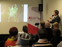 Paweł Kaźmierski podczas wykładu „Wiosenne rośliny cebulowe”, na pierwszym planie widnieje zgromadzo