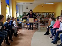 Bibliotekarka prezentuje dzieciom książki z naszych zbiorów.
