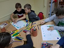 Uczestnicy zajęć tworzą prace plastyczne.