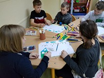 Uczestnicy zajęć tworzą prace plastyczne.