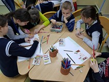 Uczestnicy zajęć tworzą prace plastyczne.