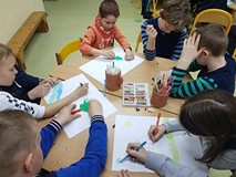 Uczestnicy zajęć tworzą prace plastyczne.