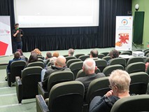 Jeden mężczyzna wita publiczność zgromadzoną  na projekcji filmu z cyklu Miasto Na Przykład pt. „La 