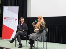 Dwie kobiety siedzą na krzesłach i prowadzą dyskusję na temat filmu z cyklu Miasto Na Przykład pt. „