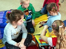 Dzieci przeglądają książeczki ze zbiorów biblioteki