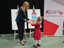 Z-ca dyrektora KBP, Beata Sawa-Jovanoska wręcza nagrody uczestniczce  przeglądu dla przedszkolaków