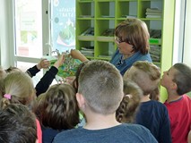 Bibliotekarka prezentuje dzieciom książkę 