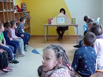 Bibliotekarka czyta grupie dzieci.
