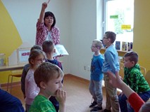 Bibliotekarka czyta grupie dzieci.