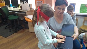 Dzieci przez dotyk zapoznają się z ilustracją książki 