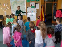 Dzieci wykonują ruchy zgodne z pokazywanymi przez bibliotekarkę strzałkami