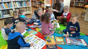 Dzieci oglądają książki z naszego księgozbioru