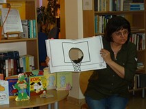Bibliotekarka prezentuje dzieciom Książkę z dziurą