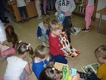 Dzieci przeglądają książeczki ze zbiorów biblioteki