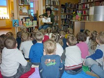 Bibliotekarka prezentuje dzieciom książki z naszych zbiorów.