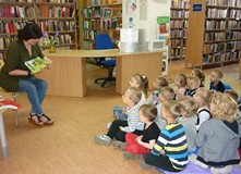 Bibliotekarka prezentuje dzieciom książki z naszych zbiorów.