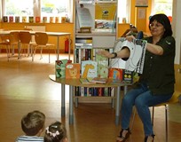 Bibliotekarka prezentuje dzieciom Książkę z dziurą