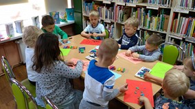 Zajęcia plastyczne, dzieci wyklejają plasteliną pszczoły i motyle
