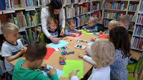 Zajęcia plastyczne, dzieci wyklejają plasteliną pszczoły i motyle