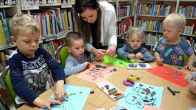 Zajęcia plastyczne, dzieci wyklejają plasteliną pszczoły i motyle