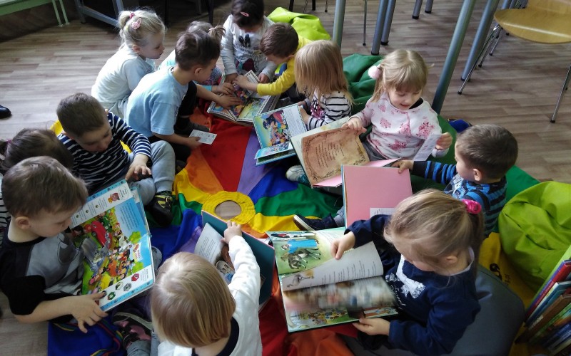 Grupa dzieci ogląda książki
