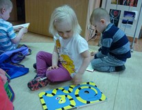 Dzieci oglądają książeczki z biblioteczki malucha