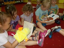 Dzieci oglądają książeczki i bawią się pacynkami