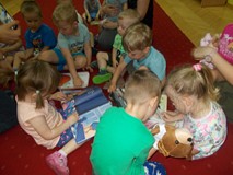 Dzieci oglądają książeczki i bawią się pacynkami