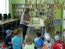 Bibliotekarka objaśnia dzieciom, czym jest teatrzyk kamishibai