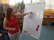 bibliotekarka zapisuje na tablicy oceny klubowiczów