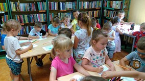 Dzieci kolorują laurki dla taty.