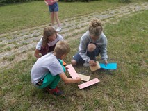 Dzieci wykonują zadania na dworze w grupach