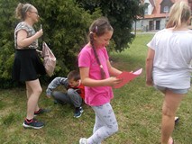 Dzieci wykonują zadania na dworze w grupach