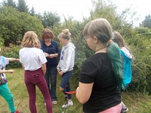 Dzieci wykonują zadania na dworze w grupach