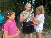 Dzieci wykonują zadania na dworze w grupach